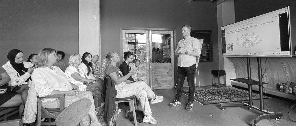 Bjorn Kiggen leitet ein interaktives Seminar über mentale Gesundheit und Resilienz vor einer Gruppe von Teilnehmern.